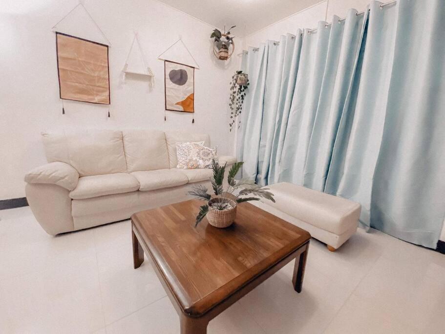 a living room with a couch and a coffee table at TRP1 - Cozy 2BR Home near Aquaplanet & Clark Airport in Tacondo