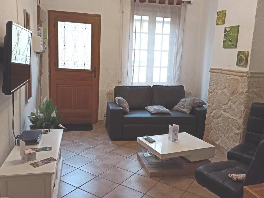 un salon avec un canapé et une table dans l'établissement Petite Maison proche de la plage, à Grand-Fort-Philippe