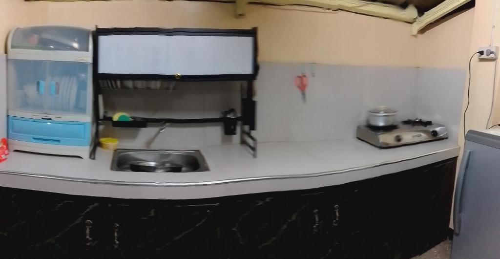 eine Küchentheke mit Spüle und Fenster in der Unterkunft Guyangan Homestay Siargao in Catangnan