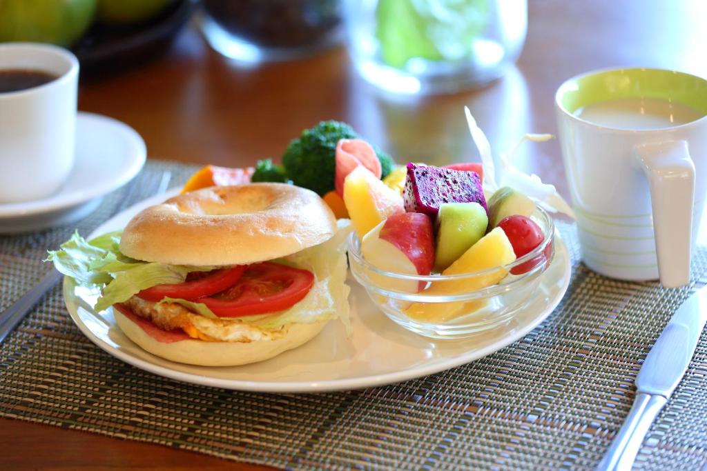 a plate with a sandwich and a bowl of fruit at 大花紫薇田園民宿 in Ji&#39;an