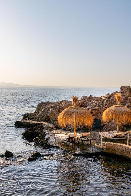 a group of chairs and umbrellas on the beach at Hotel de Mar Gran Meliá - Adults Only - The Leading Hotels of the World in Illetas