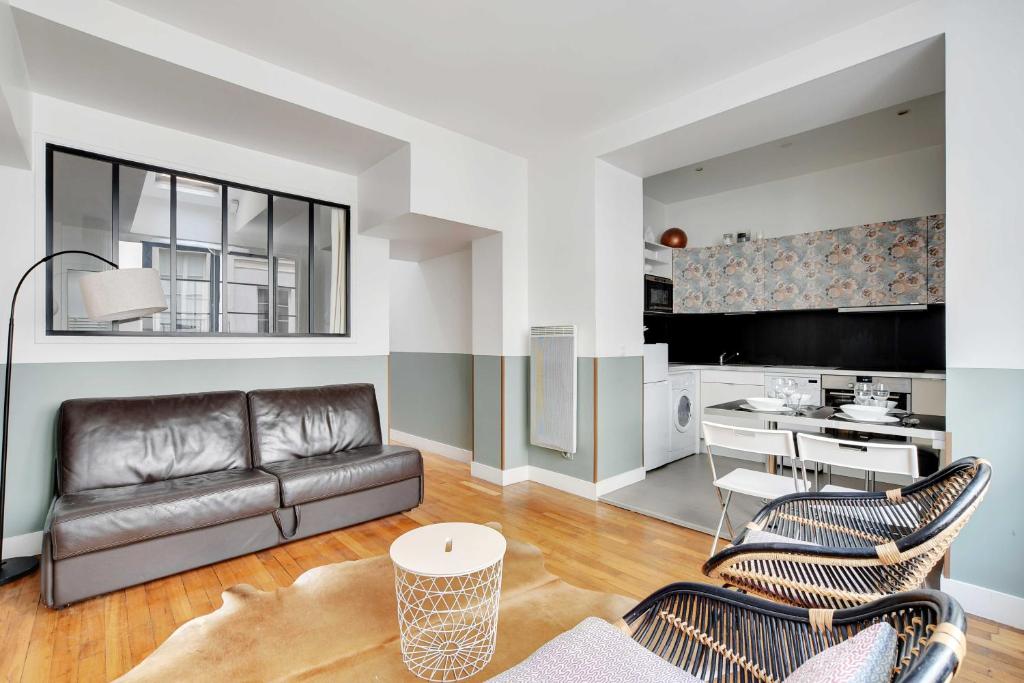 un salon avec un canapé et des chaises et une cuisine dans l'établissement Charming apartment - 1BR-6P - Sentier, à Paris