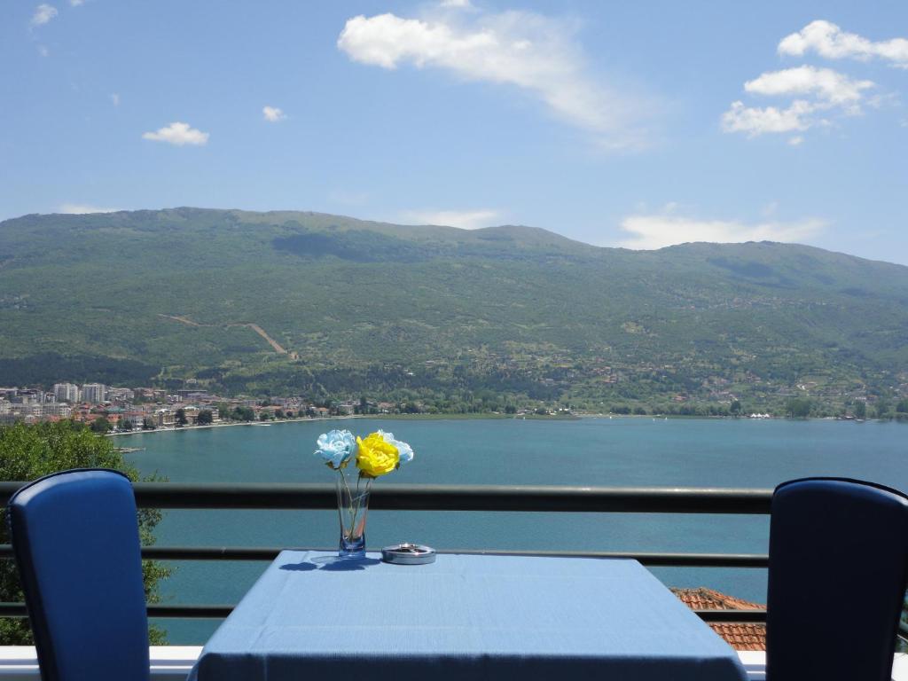 een blauwe tafel met een vaas met bloemen op een balkon bij Accommodation JT Old Town Historical sites in Ohrid