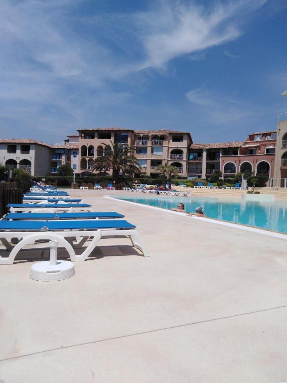 une rangée de chaises longues bleues à côté d'une piscine dans l'établissement Appartement T2 avec piscine a 100 m de la plage, à Six-Fours-les-Plages