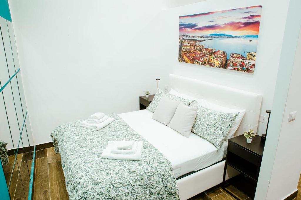una piccola camera con un letto e un dipinto sul muro di Chiaia Exclusive Apartment a Napoli