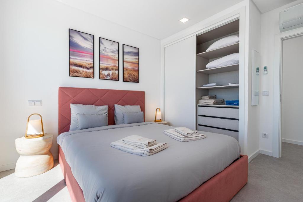 a bedroom with a large bed with a red headboard at Villa Locki in Lourinhã