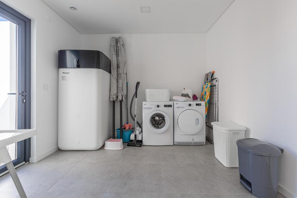 a white laundry room with a washer and dryer at Villa Locki in Lourinhã