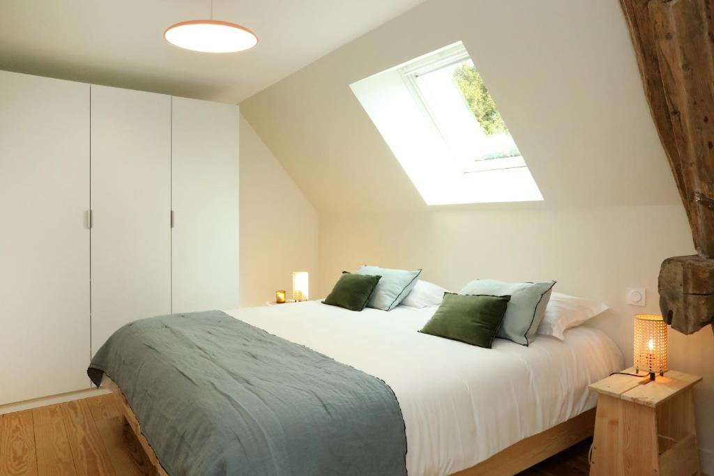 une chambre avec un grand lit blanc avec des oreillers verts dans l'établissement Le Jardin d'Aimee by La boite en Plus, à Villers-Saint-Frambourg