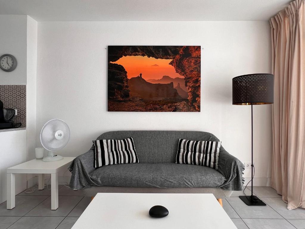 a living room with a couch and a painting on the wall at Yumbo Sunset Suite Tanife - Next to Yumbo in Playa del Ingles