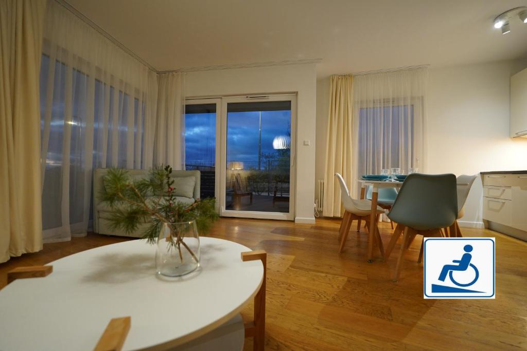 ミエルノにあるApartament przy plaży 3のテーブルと椅子のあるキッチンとリビングルーム