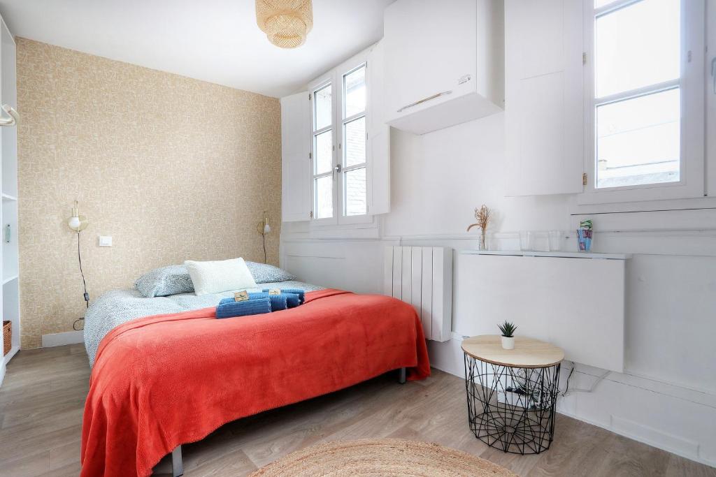 une chambre avec un lit avec une couverture rouge dans l'établissement L'Artiste, à Rennes