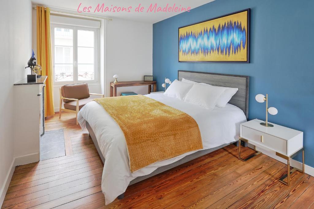 une chambre avec un grand lit avec un mur bleu dans l'établissement Nouveau - Jolie Pépite Le Rabelais, à Nantes