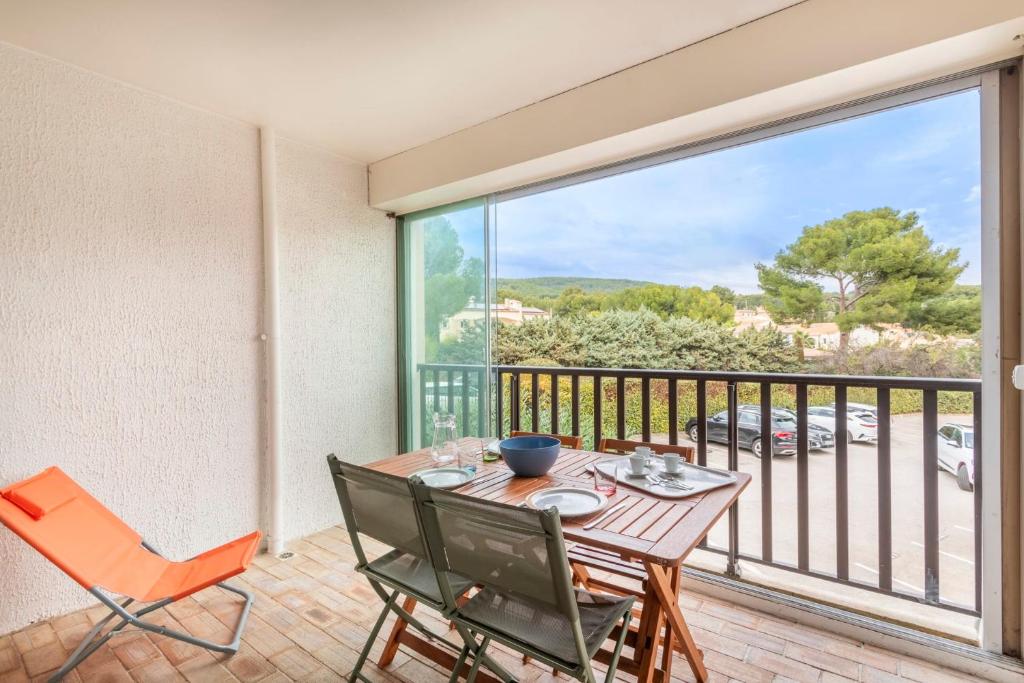 une salle à manger avec une table et des chaises et un balcon dans l'établissement Studio Argonautes - Welkeys, à Bandol