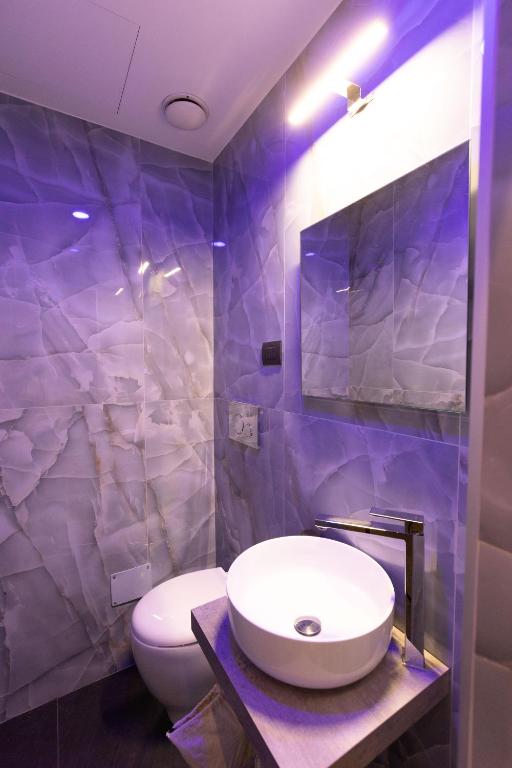 a bathroom with a white sink and a toilet at Lungomare Suite & Spa in Naples