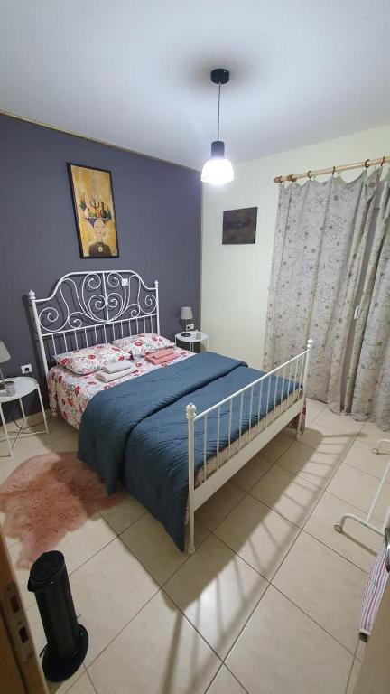 a bedroom with a bed and a blue wall at Galini Apartments in Litochoro
