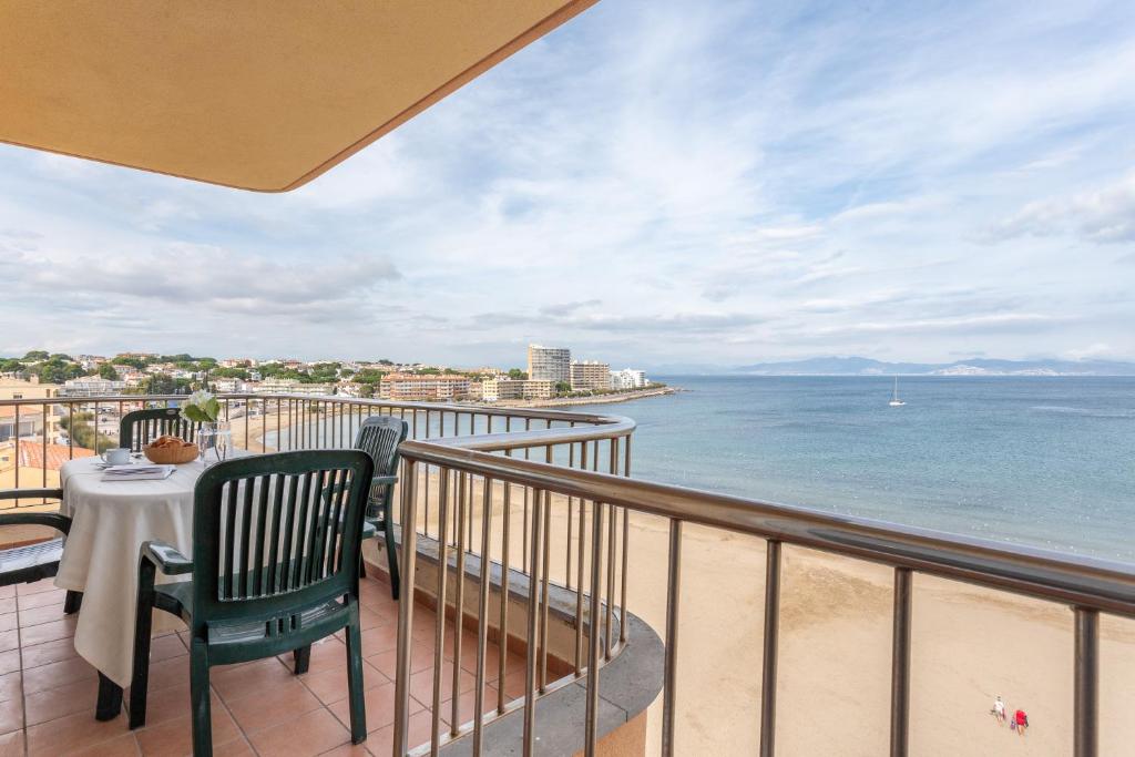 a balcony with a table and chairs and the ocean at Apartamento Blaucel in L'Escala