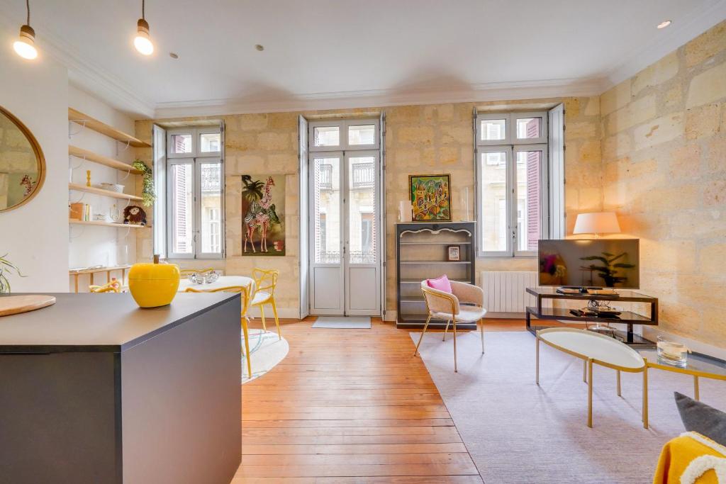 un salon avec une table et des chaises et une cuisine dans l'établissement MDOR - La Fée Girafe, à Bordeaux
