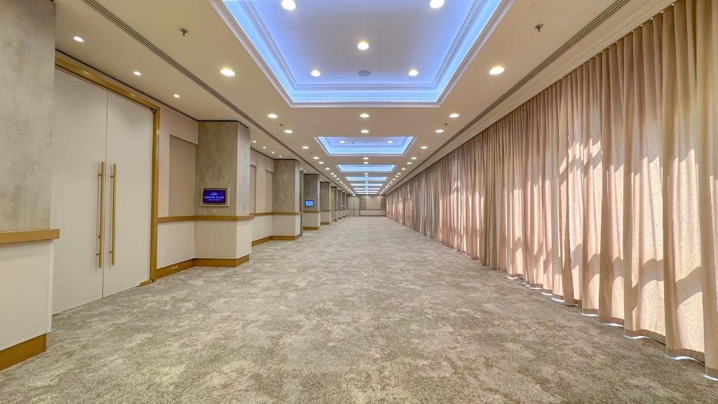 a corridor of an office building with a blue ceiling at Crowne Plaza Bahrain by IHG in Manama