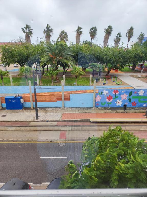 a park with palm trees and a blue fence at Close to the sea, large 170 m2 apartmentBIKES in Valencia
