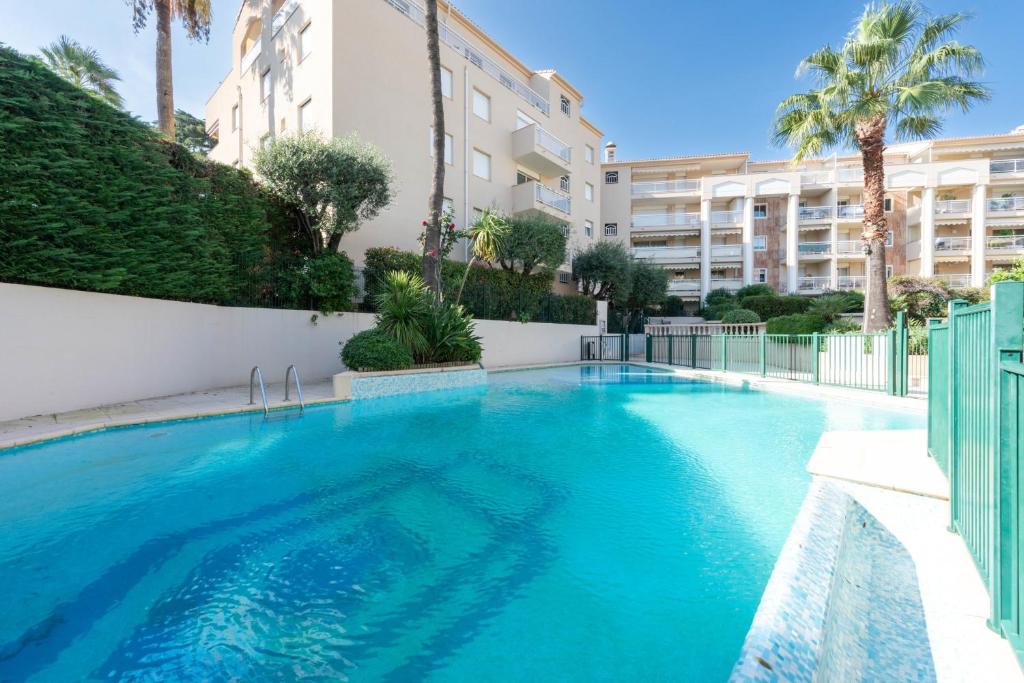 une grande piscine bleue avec un bâtiment en arrière-plan dans l'établissement 2-Br Quiet Infinity Pool & Private Parking, à Cannes