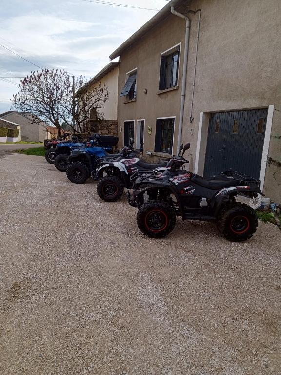 Une rangée de quatre places stationnées à côté d'un bâtiment dans l'établissement Quad-Adventure, à Ainvelle