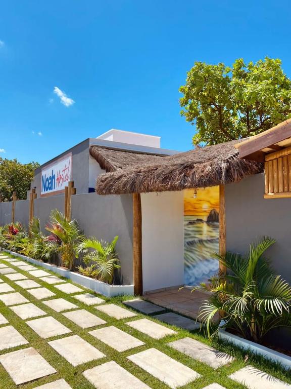 a small building with a thatched roof at Noah Hostel & Chale in São Miguel do Gostoso
