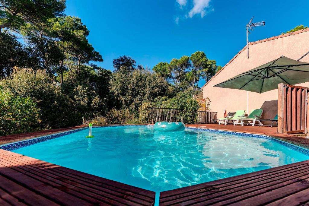 a swimming pool with an umbrella in a yard at La Sauvergine - Maison 8 personnes parc du verdon in Sillans-la Cascade