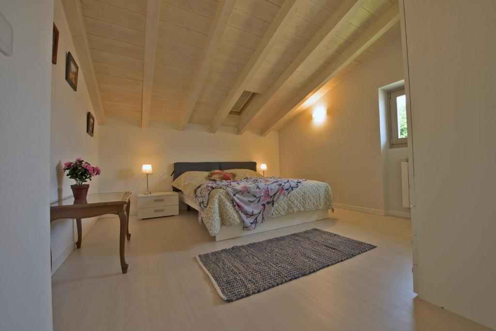 a bedroom with a bed and a table and a window at Casa Rita Fonteno in Fonteno