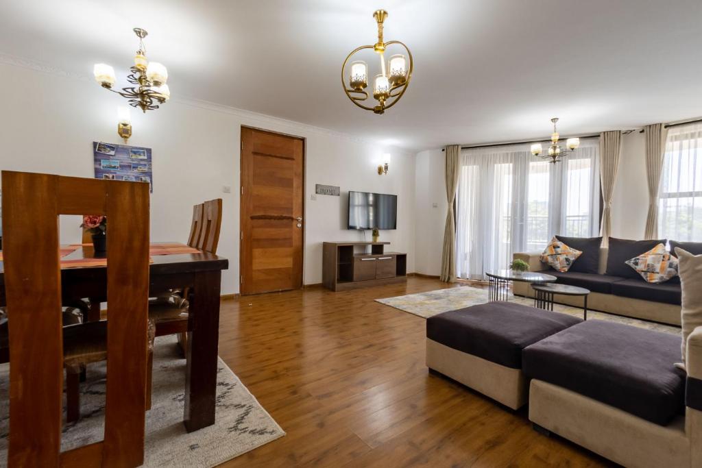 a living room with a table and a couch at Erica Residences - Riverside in Nairobi