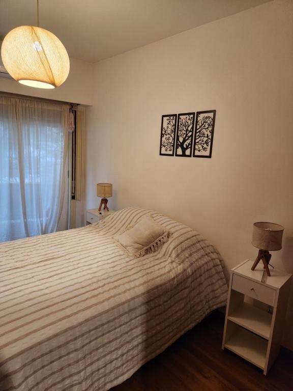 a bedroom with a bed and two lamps and a window at Sunny apartment Vicente Lopez in Vicente López