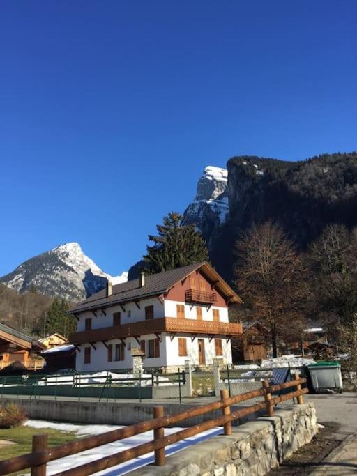 un bâtiment avec une montagne en arrière-plan dans l'établissement Grand chalet hiver été 13 p loc à la semaine du samedi au samedi, à Samoëns