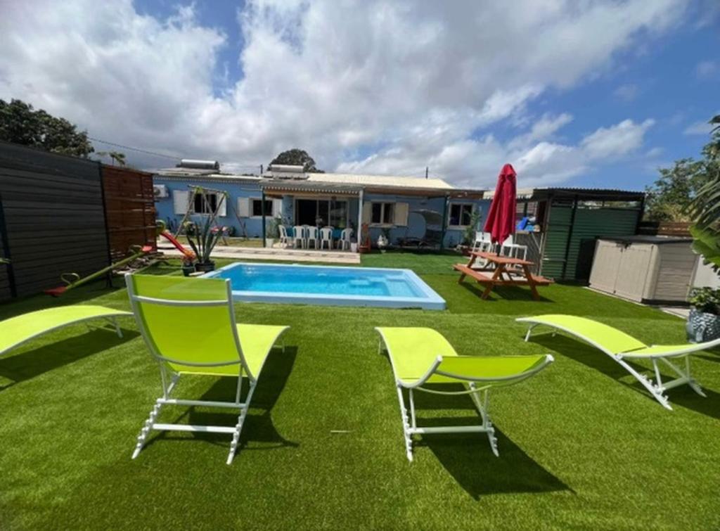 a yard with chairs and a swimming pool at Kaz à Naja in Saint-Louis