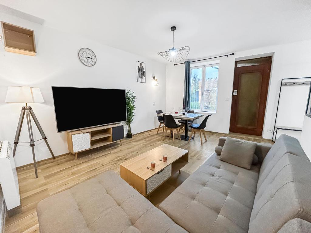 un salon avec un canapé et une télévision à écran plat dans l'établissement Maison lumineuse avec verrière & grand écran, à Saint-Leu-dʼEsserent