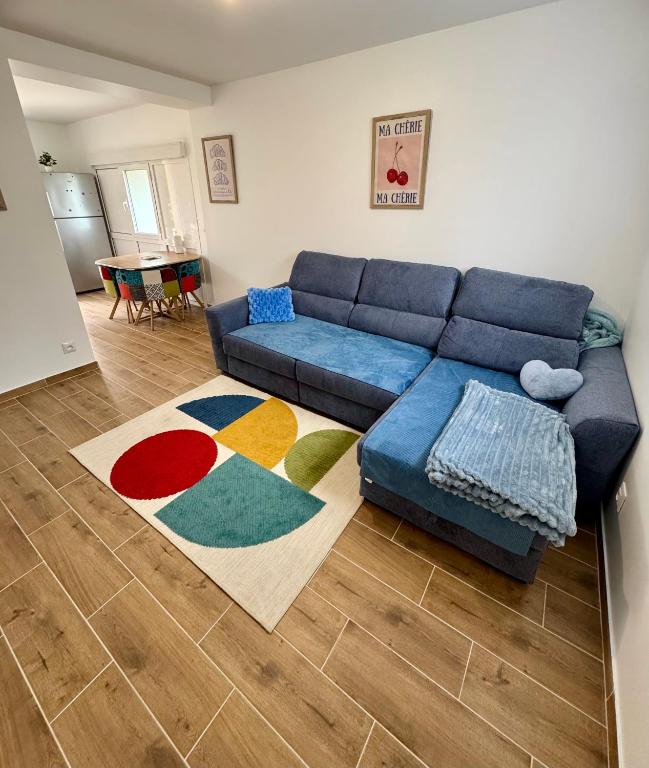 un salon avec un canapé bleu et un tapis dans l'établissement Appartement avec jardin, à Gagny