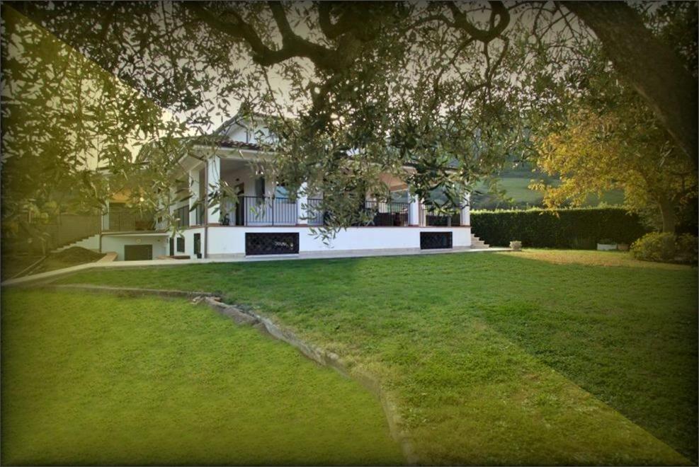 a white house with a large lawn in front of it at Just House in Campagnano di Roma