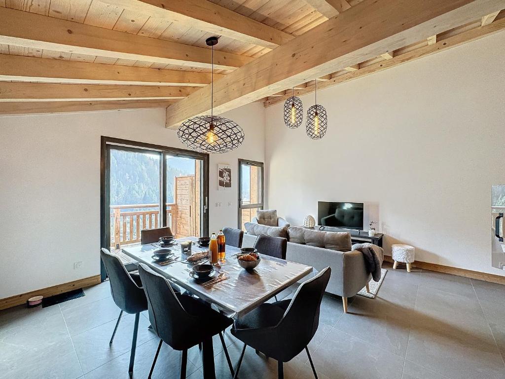 une salle à manger avec une table, des chaises et un canapé dans l'établissement Le Seraya - 5 pers- pistes à proximité, aux Gets