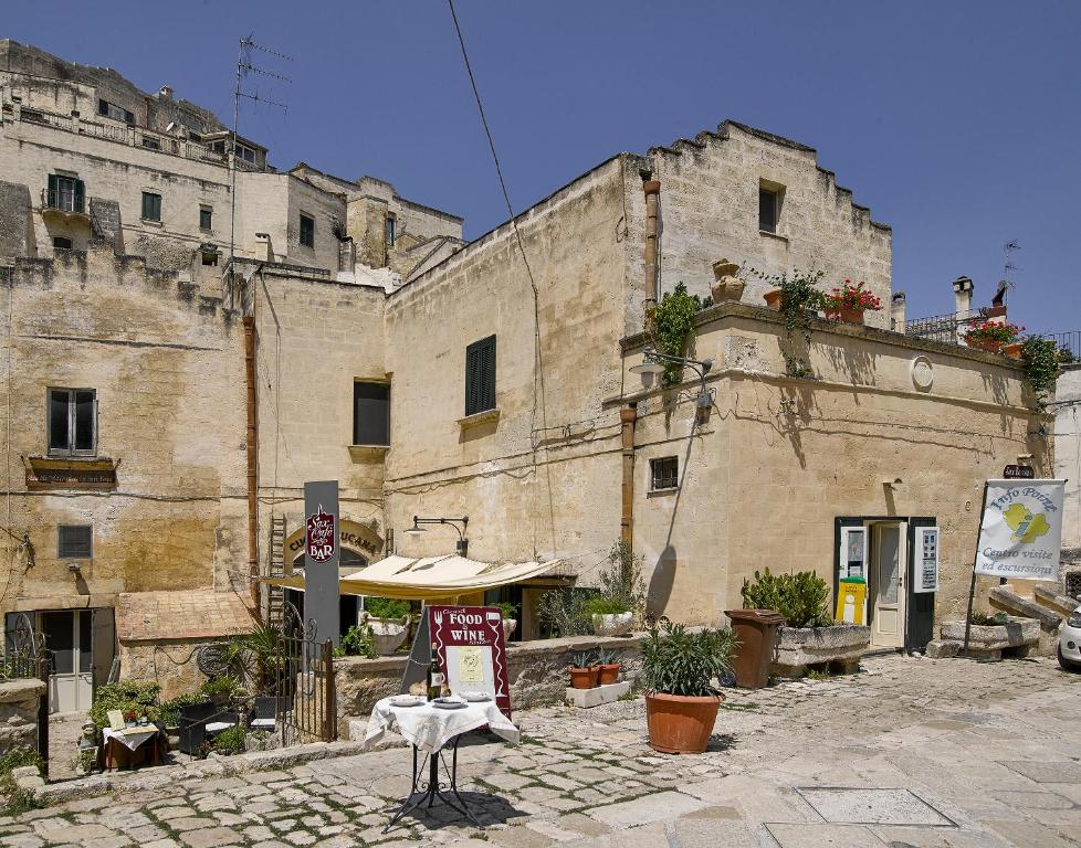 un vecchio edificio con un cartello di fronte di Sax Barisano a Matera