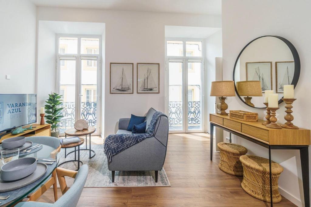a living room with a chair and a mirror at Varanda Azul - First Mate Loft (City Centre) in Ponta Delgada