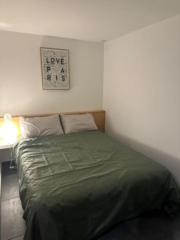 - un lit dans une chambre avec un panneau mural dans l'établissement appartement Vitry sur Seine, à Vitry-sur-Seine