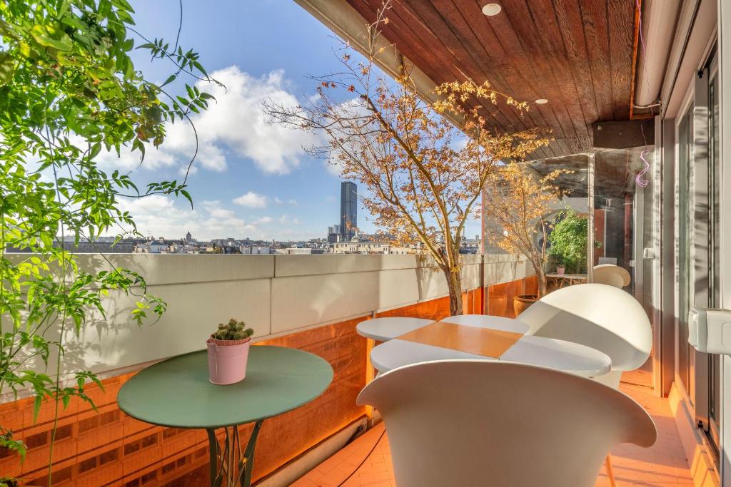 un balcon avec tables et chaises et vue sur la ville dans l'établissement Sevres- Appartement moderne proche le Bon marché, à Paris