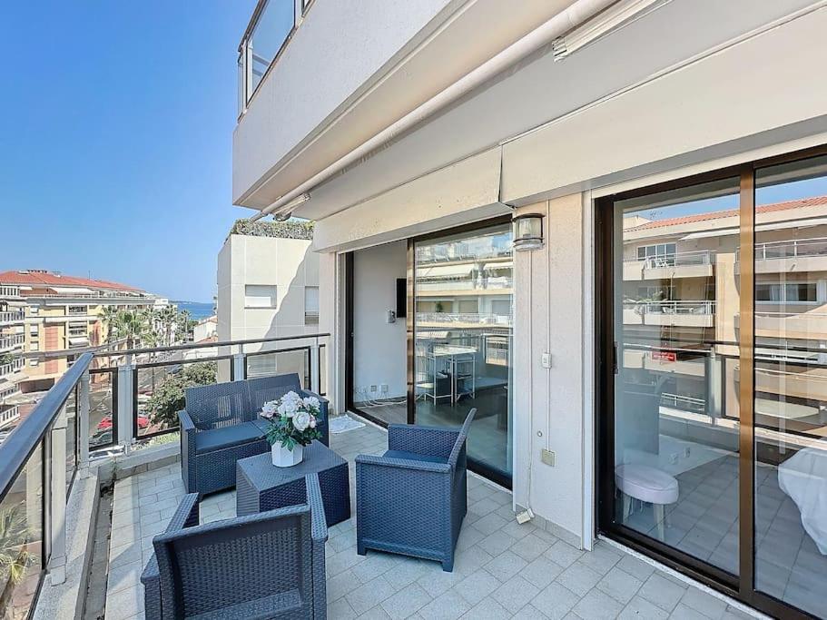 d'un balcon avec des chaises et une table fleurie. dans l'établissement 50m2 Parking, Terrasse vue Mer, à Cannes