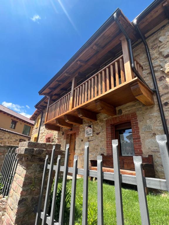 ein Haus mit einer Holzveranda und einem Zaun in der Unterkunft La Casita de Verdiago in Verdiago