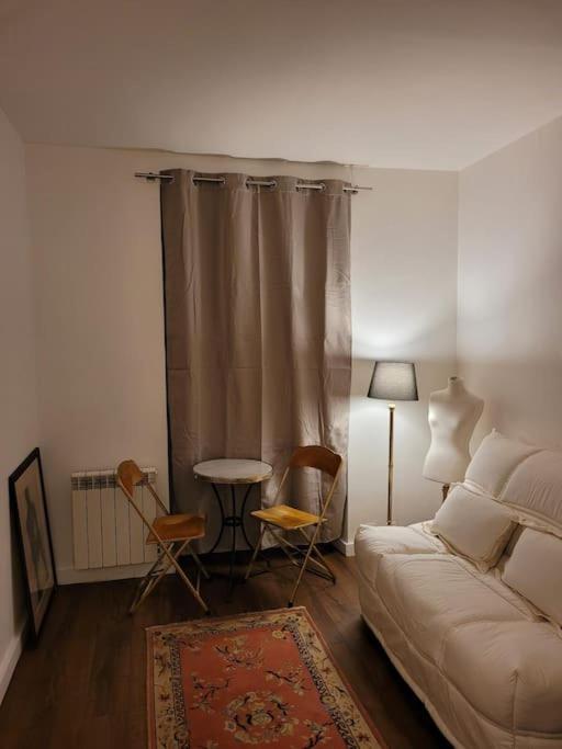 un salon avec un canapé, une table et des chaises dans l'établissement Paris Ménilmontant Studio 2 pers, à Paris