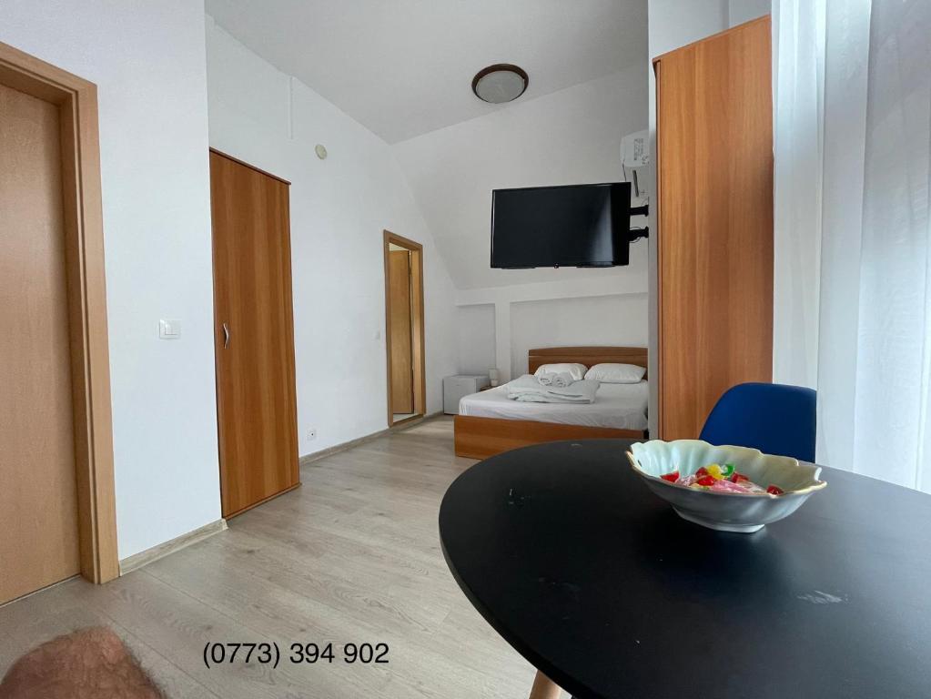 a room with a table and a bedroom with a bed at La Casa in Sibiu