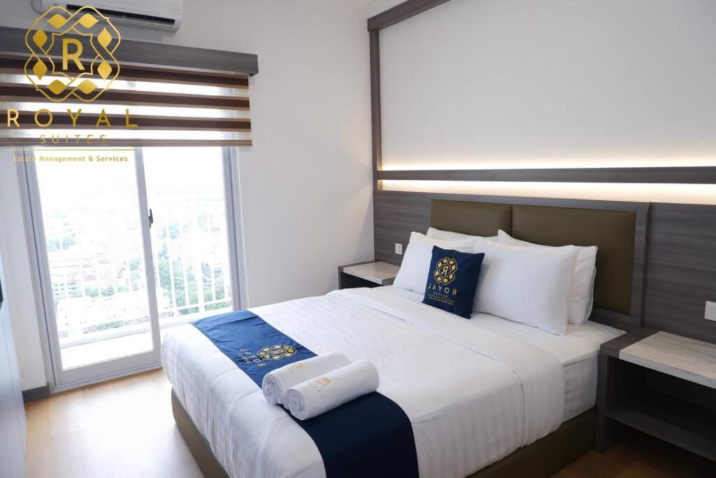 a bedroom with a large bed with a large window at Royal Suites Studio 10ZS - Citra Plaza Nagoya in Jodoh