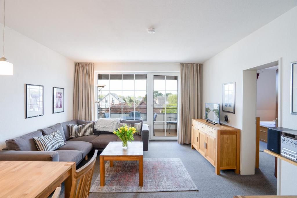 een woonkamer met een bank en een tafel bij DKK7 Ferienwohnung Abendsonne F in Niendorf