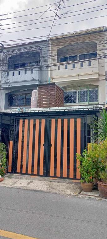 a building with a gate on the side of a street at Ben House Hatyai in Hat Yai