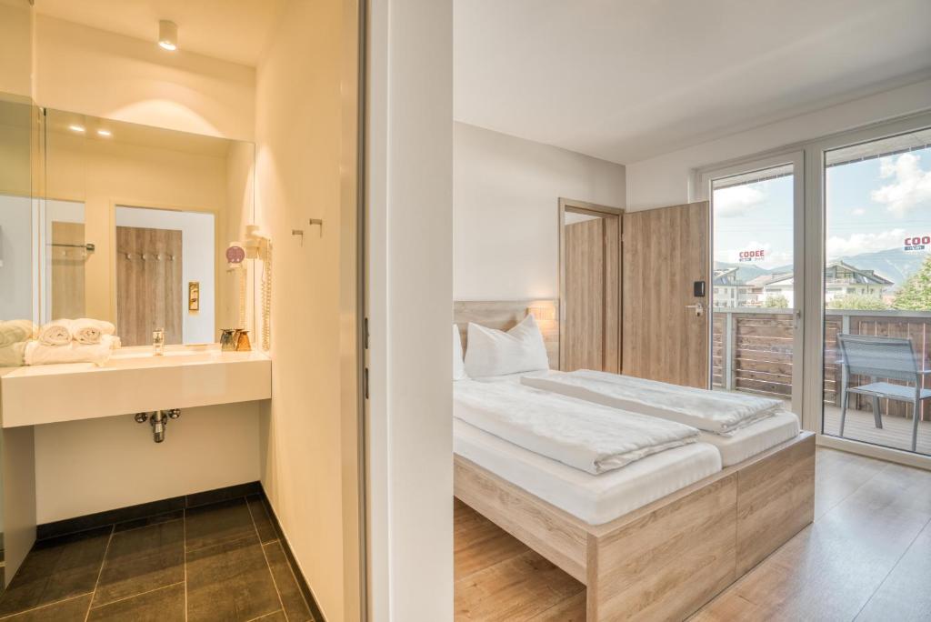 Posteľ alebo postele v izbe v ubytovaní COOEE alpin Hotel Kitzbüheler Alpen