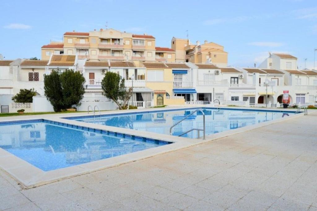 a large swimming pool in front of some buildings at Torrevieja Spectacular Townhouse in Torrevieja
