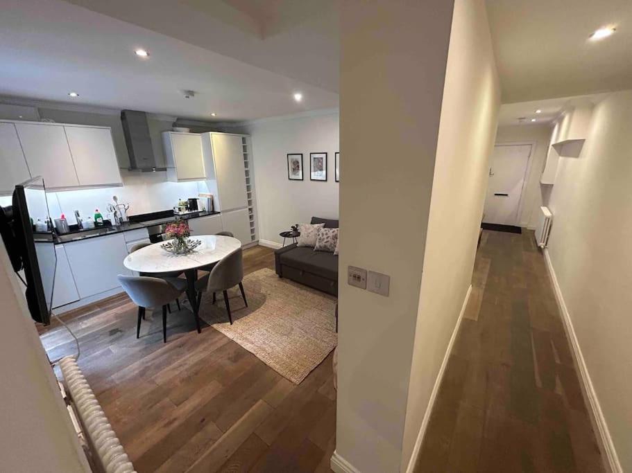 a kitchen and a living room with a table and a couch at Portobello 2-Bed Apartment in London